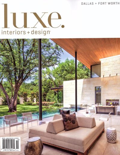 Elegant outdoor living space with modern furniture and natural stone accents featured in luxe interiors + design magazine.