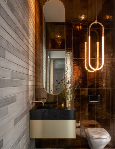 Modern bathroom interior with a wall-mounted sink, oval mirror, and decorative pendant light.