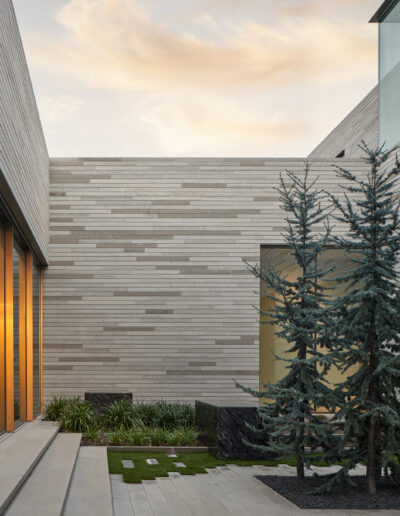 Modern architectural building with wooden facade and glass windows at dusk.