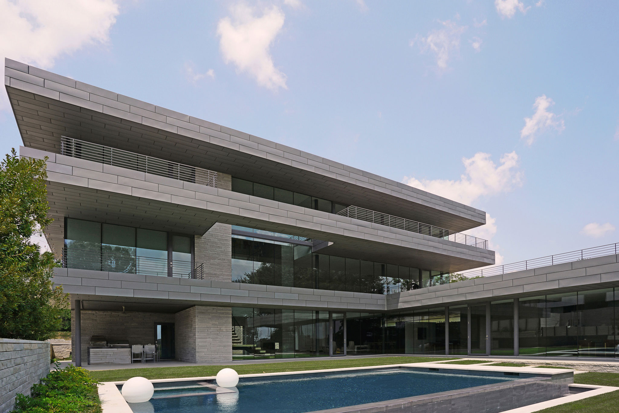 Modern architectural home with geometric design and outdoor swimming pool.