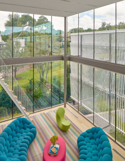 Living room area with plush sofa and floor to ceiling glass windows.